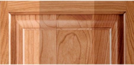 A cherry cabinet door showing warm reddish tones and flowing grain swirls.