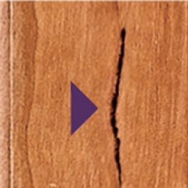 Close-up of a hairline check following the grain at a cabinet joint—a normal result of wood movement.